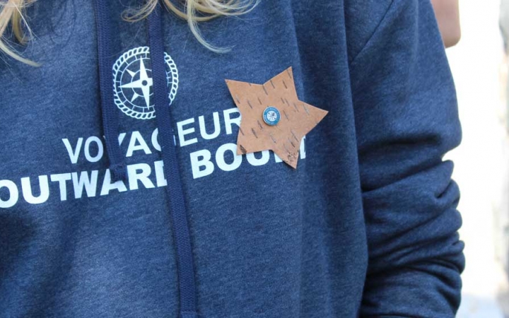 A sweatshirt reading "Voyageur Outward Bound." A star is pinned to the shirt.